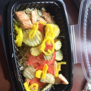 Salad with chicken banana peppers pickles tomatoes and oil and vinegar