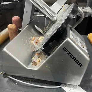 A very filthy meat, cutter and meat sitting on the counter that looks as it's been there all day