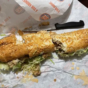 Knife for reference. #42 Chipotle Chicken Cheese Steak. Added lettuce and tomato. (Did not come eaten, we were too hungry)