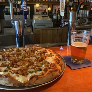 a beer and a pizza on a bar