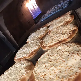 a bunch of flatbreads cooking in an oven