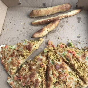 Half-eaten falafel pizza and j-bread