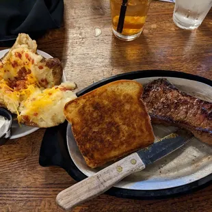 KC Strip with a slice of Texas toast and a twice baked potato.