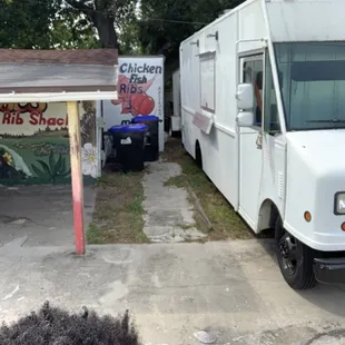 a white food truck parked in a parking lot