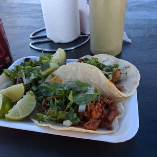 a plate of tacos and a soda