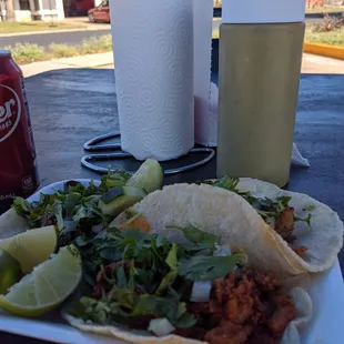 a plate of tacos and a can of soda