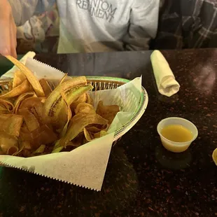 a person sitting at a table with a bowl of chips