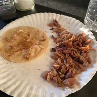 Carnita taco with beans And on the Taco are pieces of plastic that I found in my taco