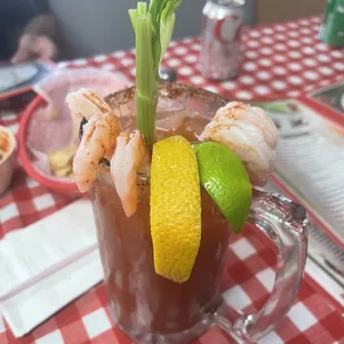 a bloody drink with shrimp and lime