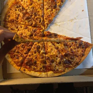 a hand holding a slice of pizza