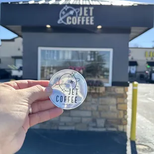 Shiny Holographic Jet Coffee Sticker in front of their coffee stand