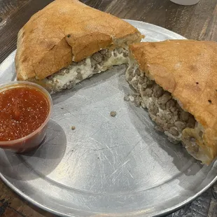 Calzone hot out of the oven and comes with a side of fresh marinara