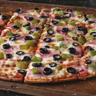 a pizza with olives and ham