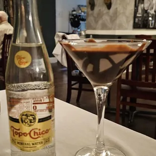 a martini and a bottle on a table