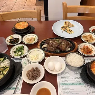 All side dishes and Bibimbap and Beef short rib and tofu soup