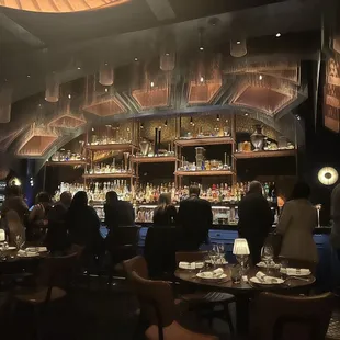 people sitting at tables in a dimly lit bar