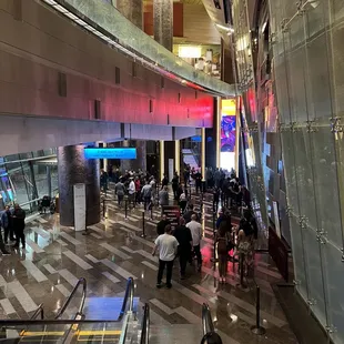 a crowd of people walking through the lobby