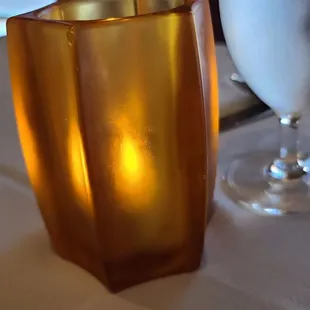a candle and a glass on a table