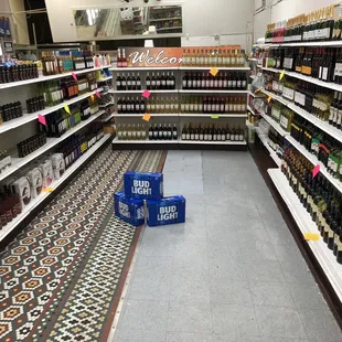 a grocery aisle with a variety of bottles of wine