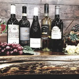 a variety of wine bottles and grapes