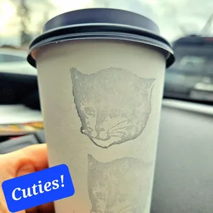 a cup of coffee with a cat drawn on it