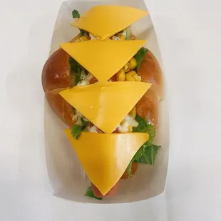 a hot dog with cheese and lettuce