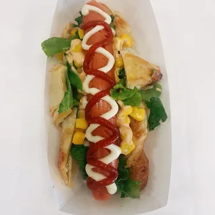 a hot dog with ketchup and corn