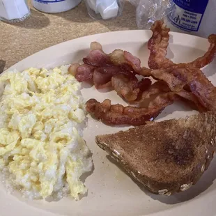 Scrambled eggs, grits, bacon and toast
