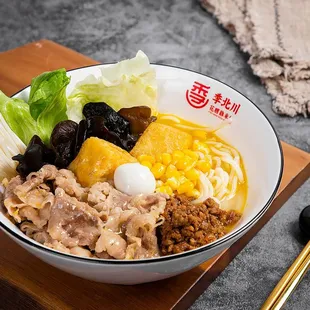 a bowl of noodles with meat and vegetables