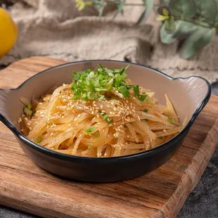 a bowl of noodles on a cutting board