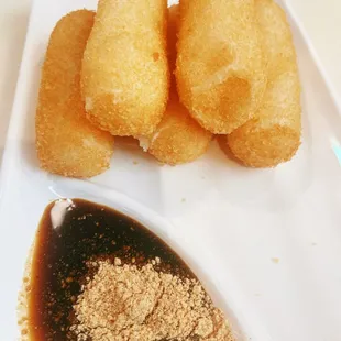 Fried rice cake served with brown sugar dipping sauce and soybean powder