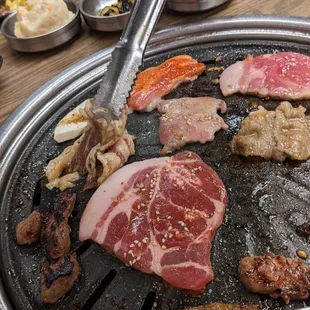 a person cutting meat on a grill