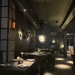 a dimly lit restaurant with tables and chairs
