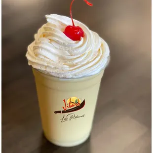 a cup of ice cream with a cherry on top