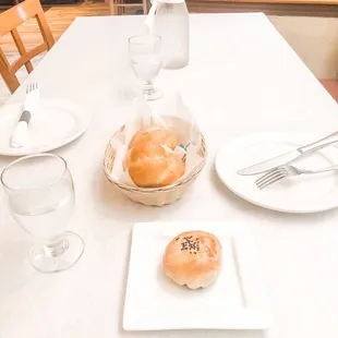 a table setting with bread and water