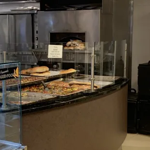 a counter with a variety of pizzas