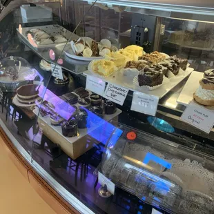 a display case filled with cakes and pastries