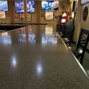 a bar with chairs and televisions