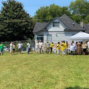 a group of people standing in front of a house