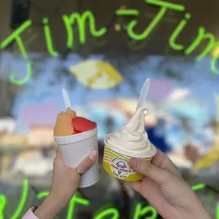 ows two people holding cups of ice cream