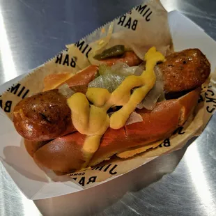 Jim &apos;N Nick&apos;s Dog, smoked chorizo, sauteed onions, bell peppers, and dijon mustard. $7.