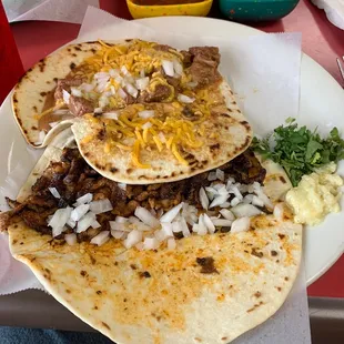 The best tacos. One Carne Guisada and one Al pastor.