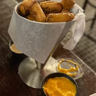 a basket of fried pretzels with mustard