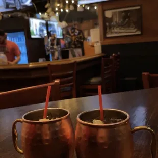 two copper mugs on a table