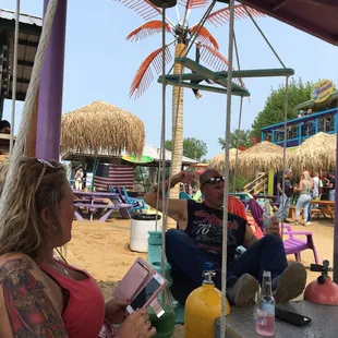 a man and a woman sitting at a table on the beach