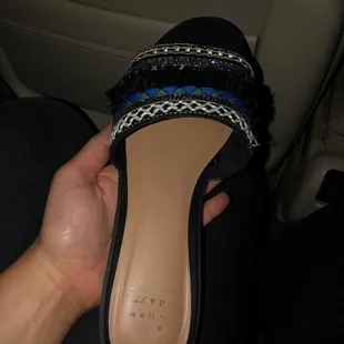 a hand holding a pair of shoes