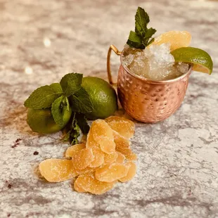 a copper mug filled with sugared oranges and mint