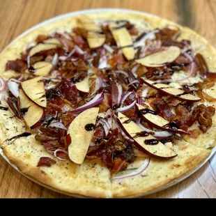 a pizza with onions and bacon