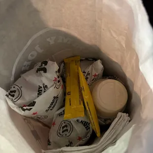 a paper bag full of condiments