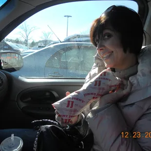 a woman in a car eating a donut